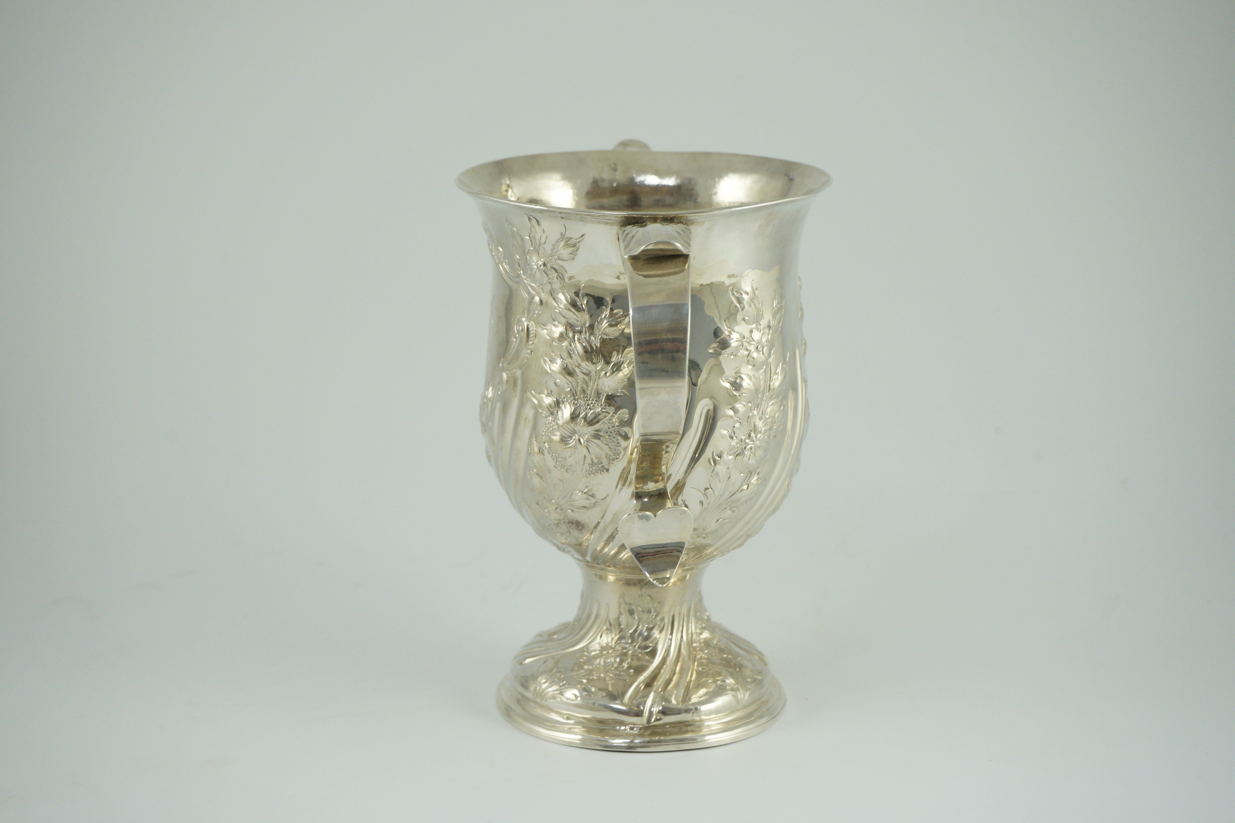 A George III silver baluster two handled pedestal cup, with later embossed decoration, by John Scofield